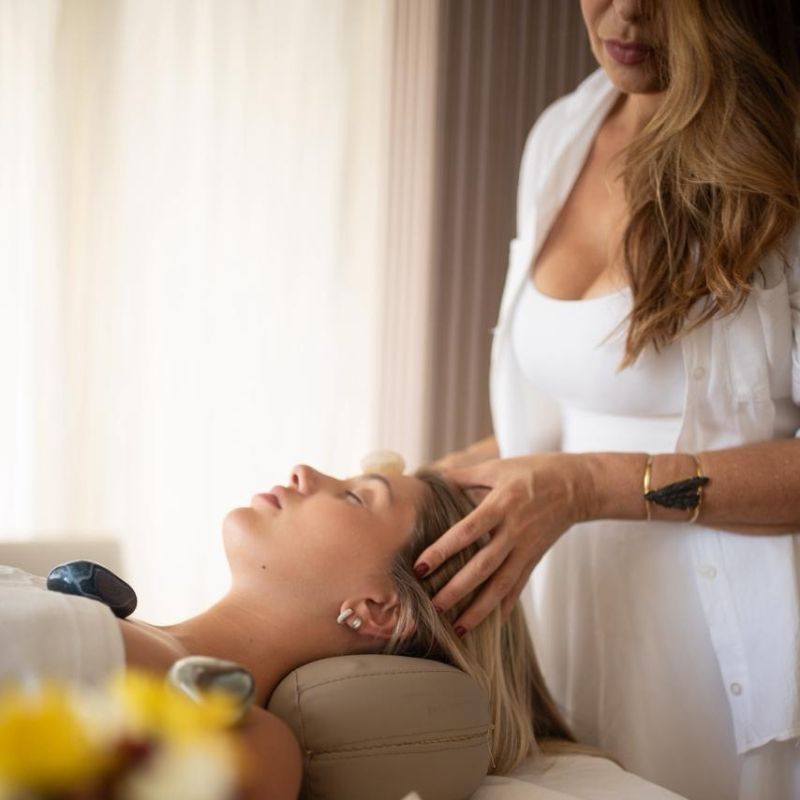Dina realizando técnica de massoterapia com atenção total ao cliente